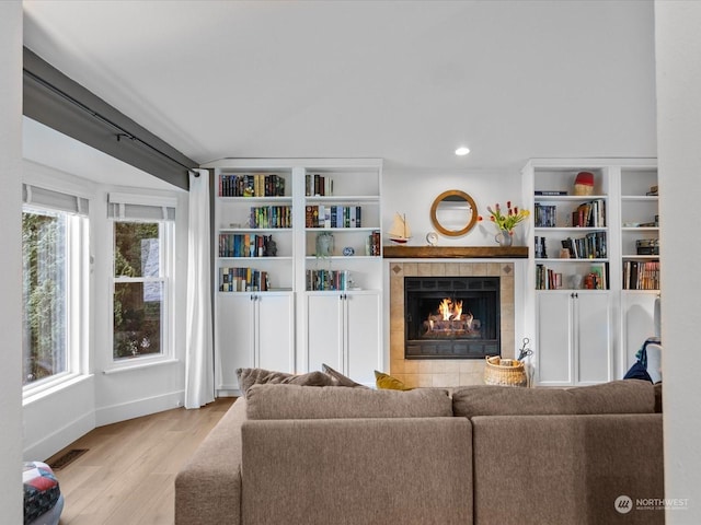 living room with a fireplace and light wood-type flooring