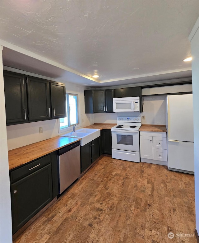 kitchen with white appliances, butcher block counters, and sink