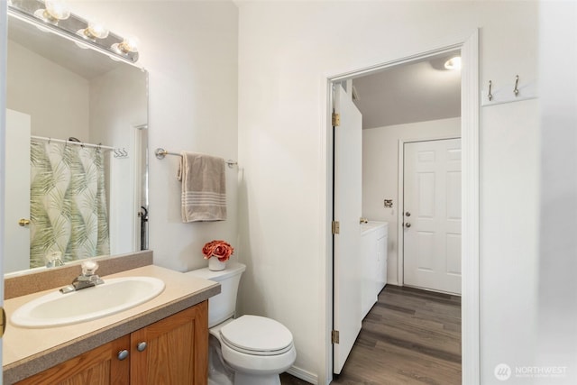 bathroom with toilet, wood finished floors, and vanity