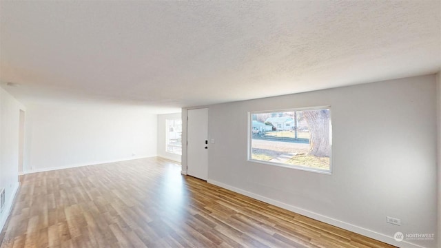 empty room featuring a textured ceiling and light wood-type flooring