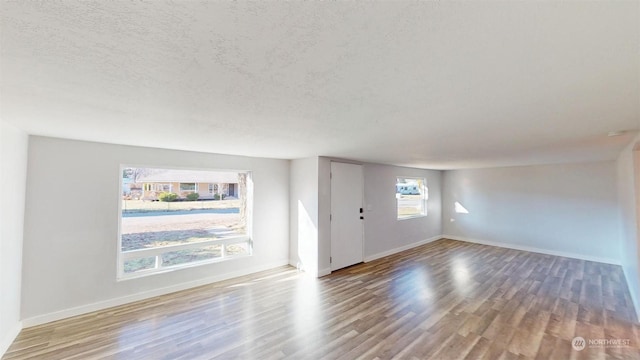 unfurnished living room featuring wood-type flooring and a textured ceiling