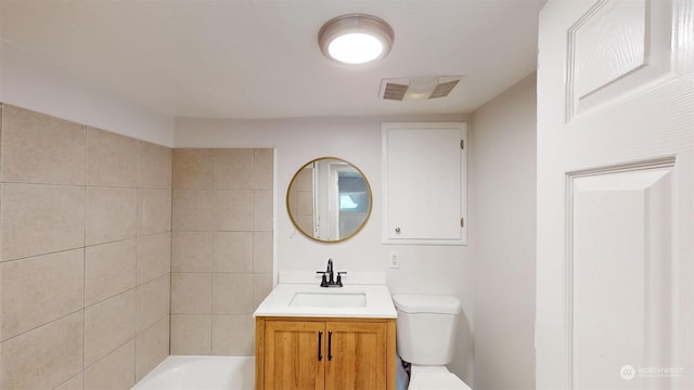 bathroom with vanity, toilet, and a bathing tub