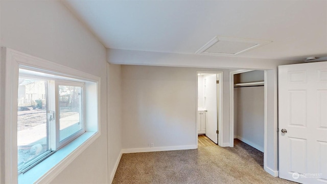 unfurnished bedroom with light colored carpet and a closet