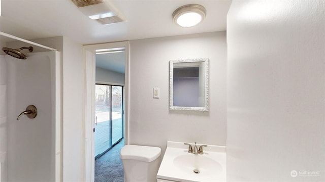 bathroom with vanity, toilet, and a shower