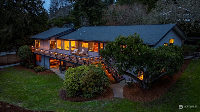 rear view of house with a wooden deck, a yard, and a patio