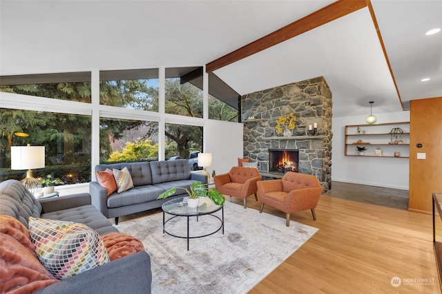 living room with beam ceiling, a stone fireplace, high vaulted ceiling, and hardwood / wood-style flooring