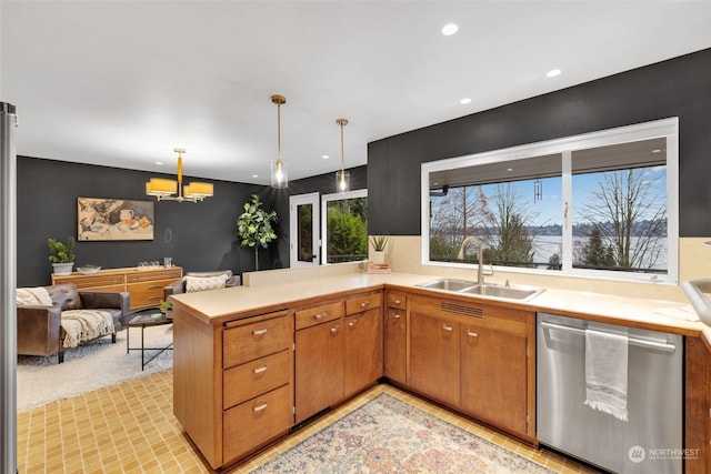 kitchen featuring sink, light carpet, dishwasher, kitchen peninsula, and pendant lighting