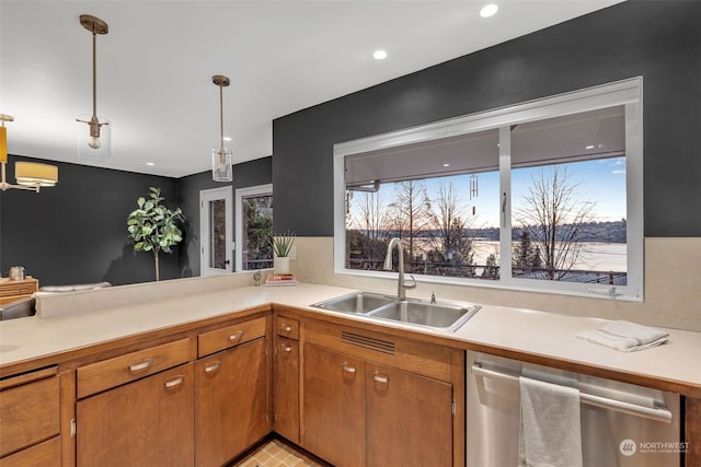 kitchen featuring decorative light fixtures, dishwasher, sink, and kitchen peninsula