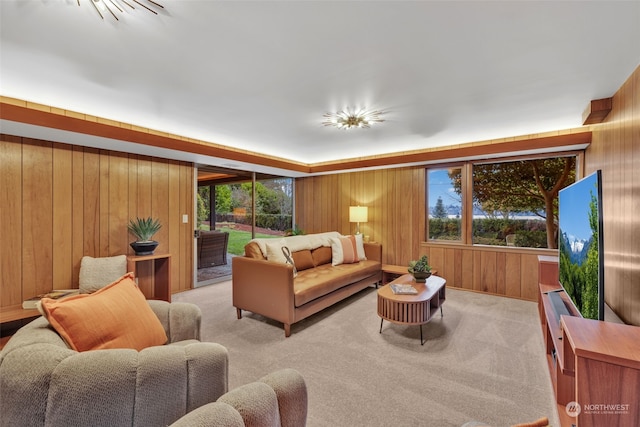 carpeted living room with a wealth of natural light and wood walls