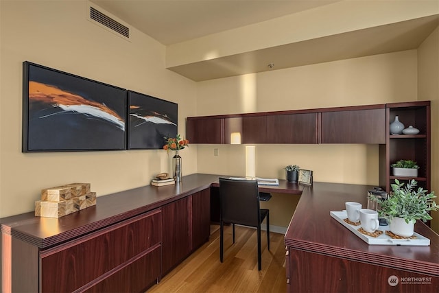 office area with built in desk and light wood-type flooring