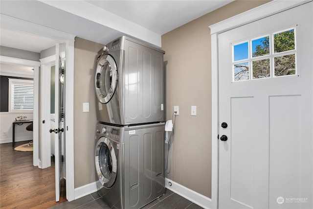 laundry room featuring stacked washer and dryer and dark hardwood / wood-style floors