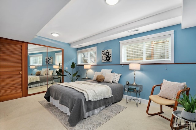 bedroom with multiple windows, carpet flooring, and a closet