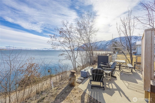 view of patio / terrace with a water and mountain view