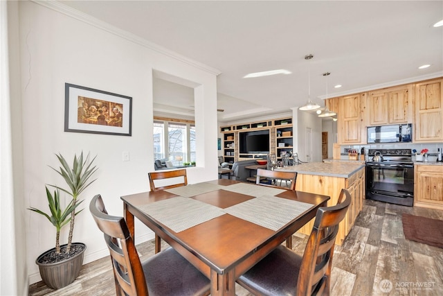 dining area with ornamental molding and light wood-type flooring