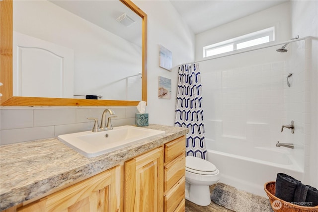 full bathroom with shower / tub combo with curtain, vanity, toilet, and backsplash