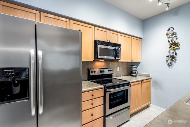 kitchen with appliances with stainless steel finishes, light brown cabinets, and decorative backsplash