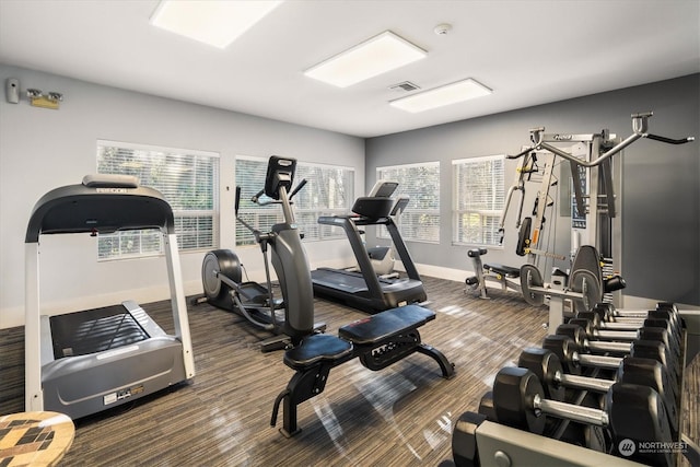 workout area with dark carpet and a wealth of natural light