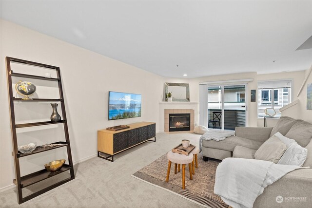 carpeted living room with a tile fireplace