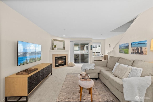 living room featuring a tiled fireplace and carpet