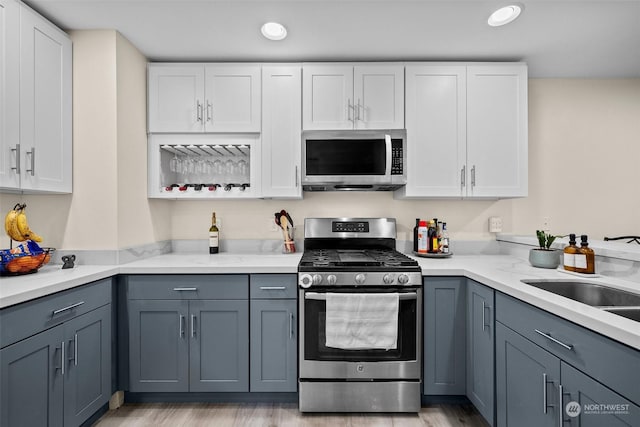 kitchen featuring stainless steel appliances, sink, white cabinets, and gray cabinets