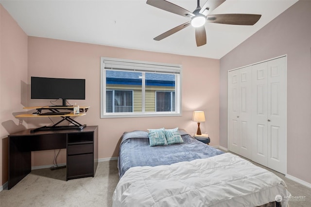 bedroom with ceiling fan, a closet, vaulted ceiling, and light carpet