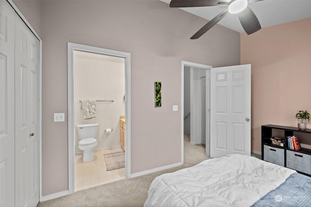 bedroom with ceiling fan, light carpet, ensuite bath, and a closet