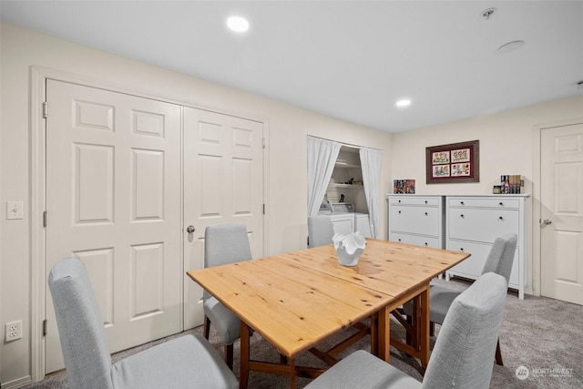 carpeted dining area featuring washer and clothes dryer