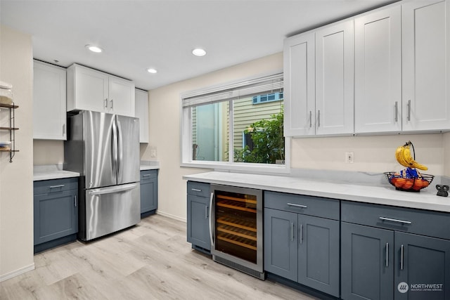 kitchen featuring gray cabinetry, light hardwood / wood-style flooring, stainless steel refrigerator, beverage cooler, and white cabinets