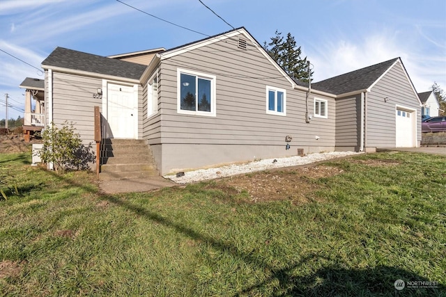 back of house featuring a yard and a garage