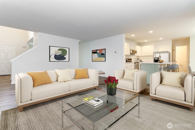 living room with light wood-type flooring and recessed lighting