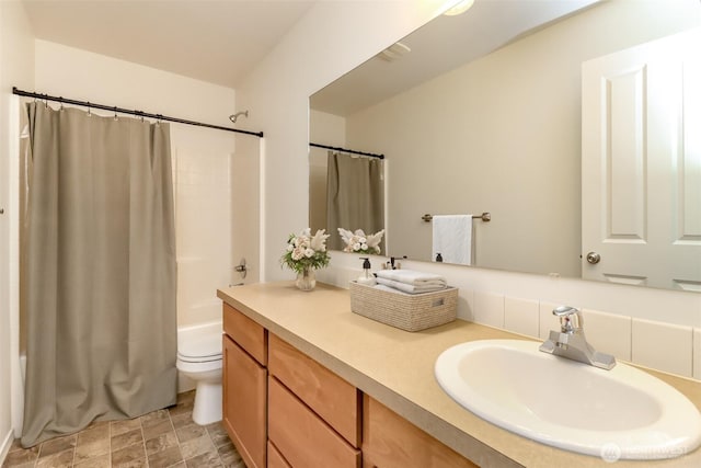 full bath with toilet, shower / bath combo with shower curtain, and vanity