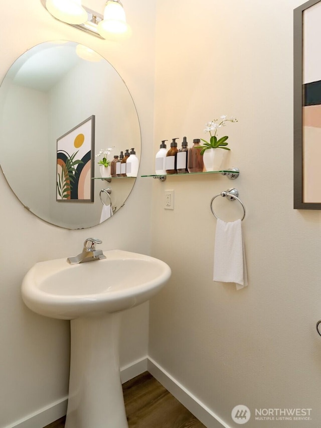 bathroom featuring wood finished floors, a sink, and baseboards
