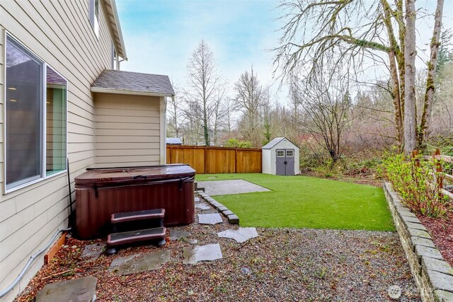 view of yard featuring an outdoor structure, a patio area, a fenced backyard, a storage shed, and a hot tub