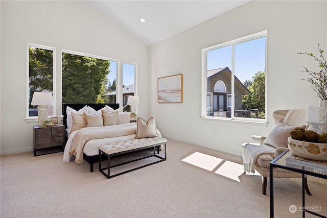 bedroom featuring multiple windows, lofted ceiling, and light carpet