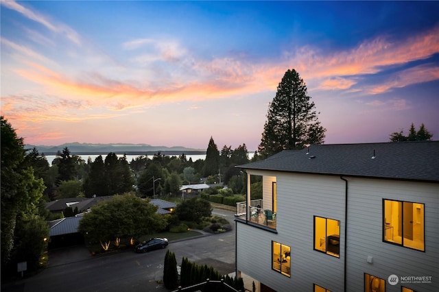 property exterior at dusk featuring a balcony