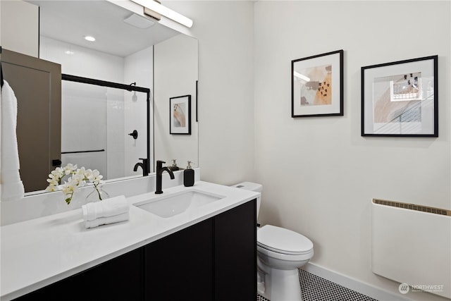 bathroom featuring vanity, radiator, an enclosed shower, and toilet