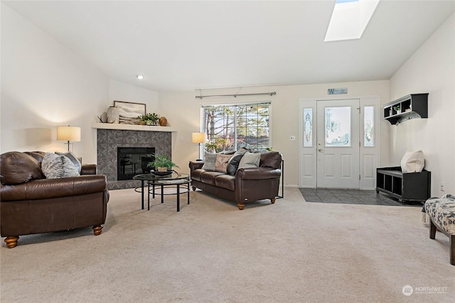 carpeted living room featuring vaulted ceiling with skylight and a high end fireplace