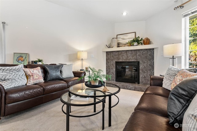 carpeted living room featuring a tile fireplace