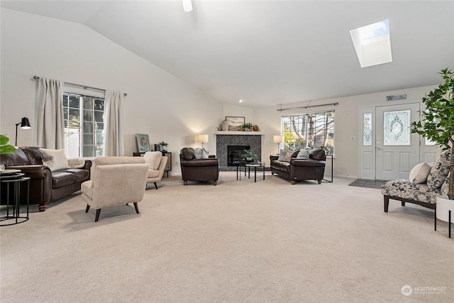 carpeted living room with lofted ceiling with skylight