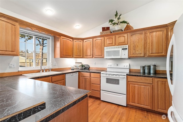 kitchen with vaulted ceiling, white appliances, light hardwood / wood-style floors, and sink