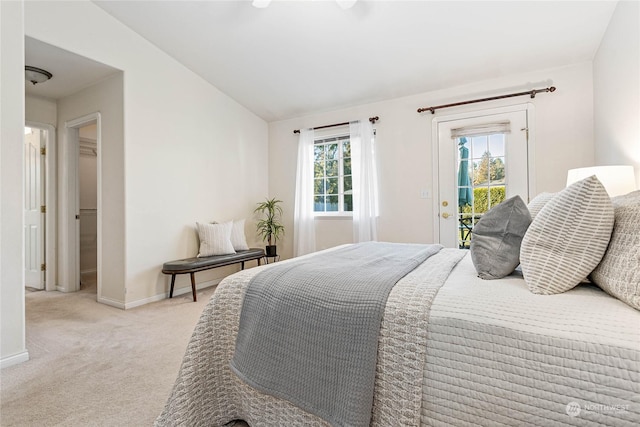 bedroom with light colored carpet, lofted ceiling, multiple windows, and access to outside