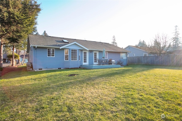 rear view of property with a yard and a deck