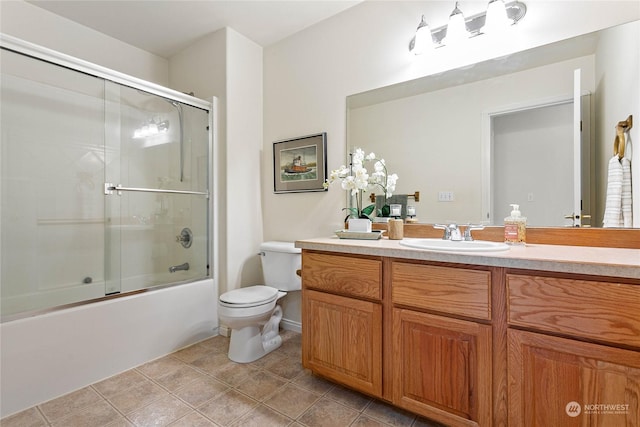 full bathroom featuring vanity, tile patterned floors, shower / bath combination with glass door, and toilet