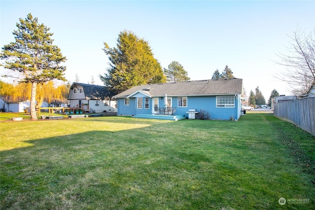 rear view of property featuring a yard and a deck