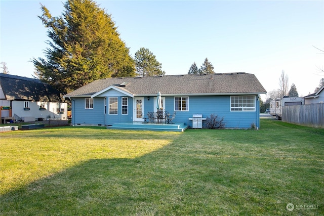 rear view of house featuring a deck and a lawn