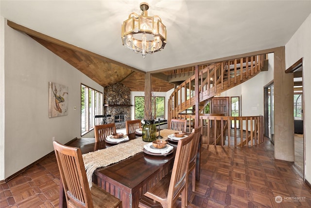 dining area with vaulted ceiling, dark parquet floors, a notable chandelier, and a fireplace