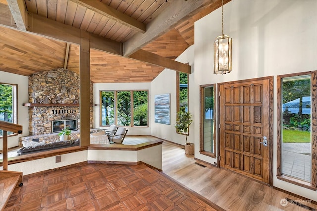 foyer entrance featuring hardwood / wood-style floors, wood ceiling, a stone fireplace, and a healthy amount of sunlight