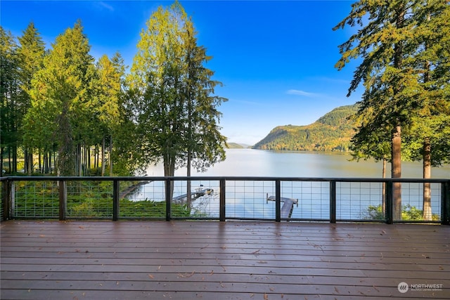 wooden deck with a water and mountain view