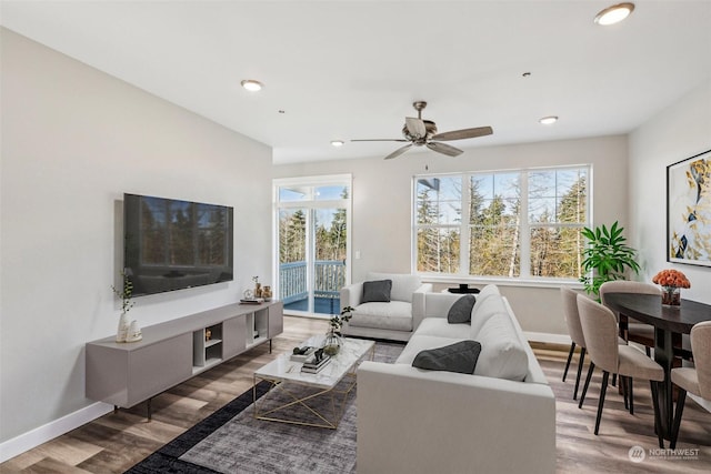 living room with wood-type flooring and ceiling fan