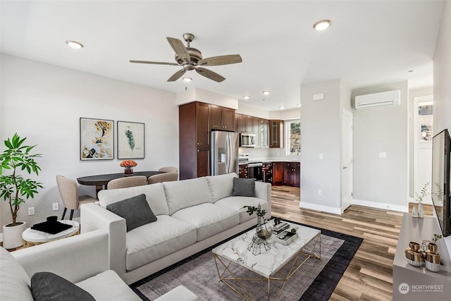 living room with ceiling fan, wood-type flooring, and a wall mounted AC